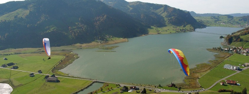 Zwei Hochleister-Gleitschirme soaren im kleinen und feinen Fluggebiet Euthal am Sihlsee.