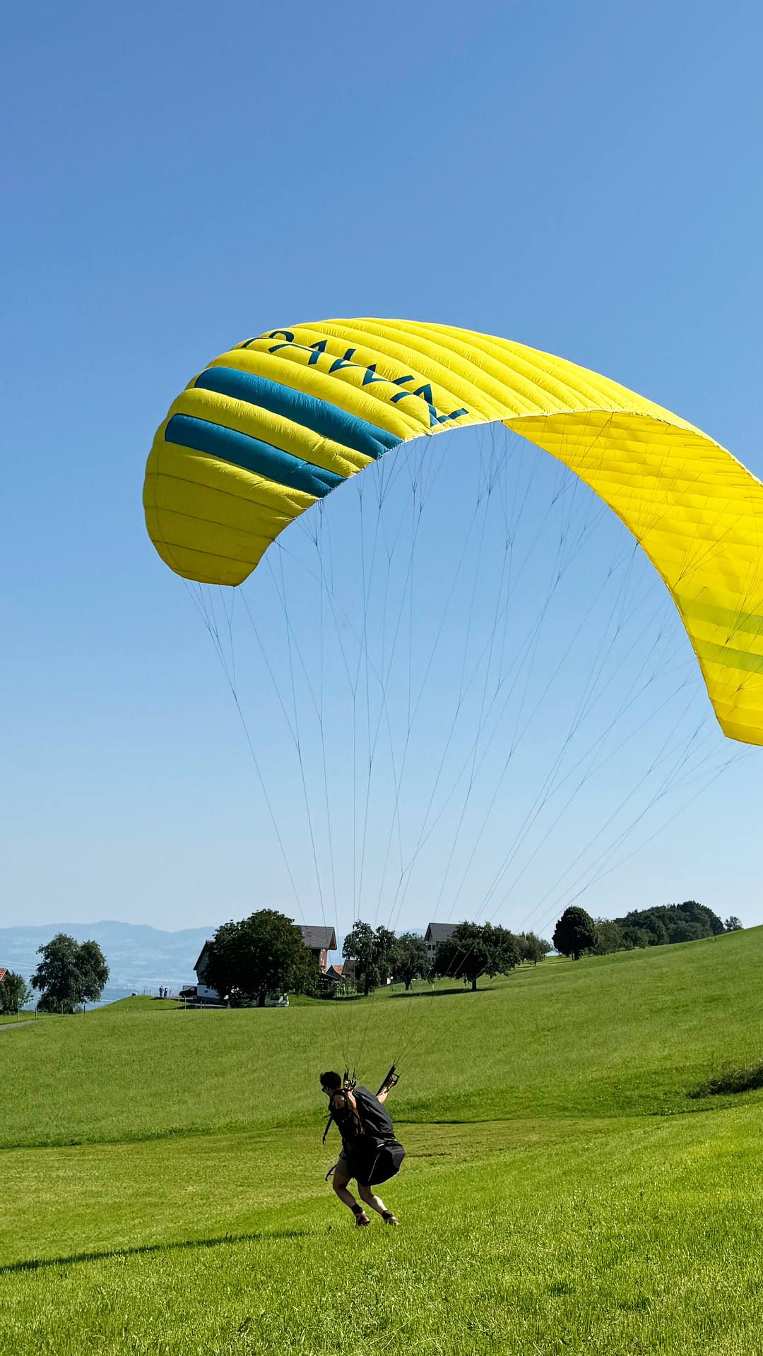 Eine Flugschülerin hat mit Schritten am Boden genau unter der Mitte des Gleitsegels volle Kontrolle über das Fluggerät.