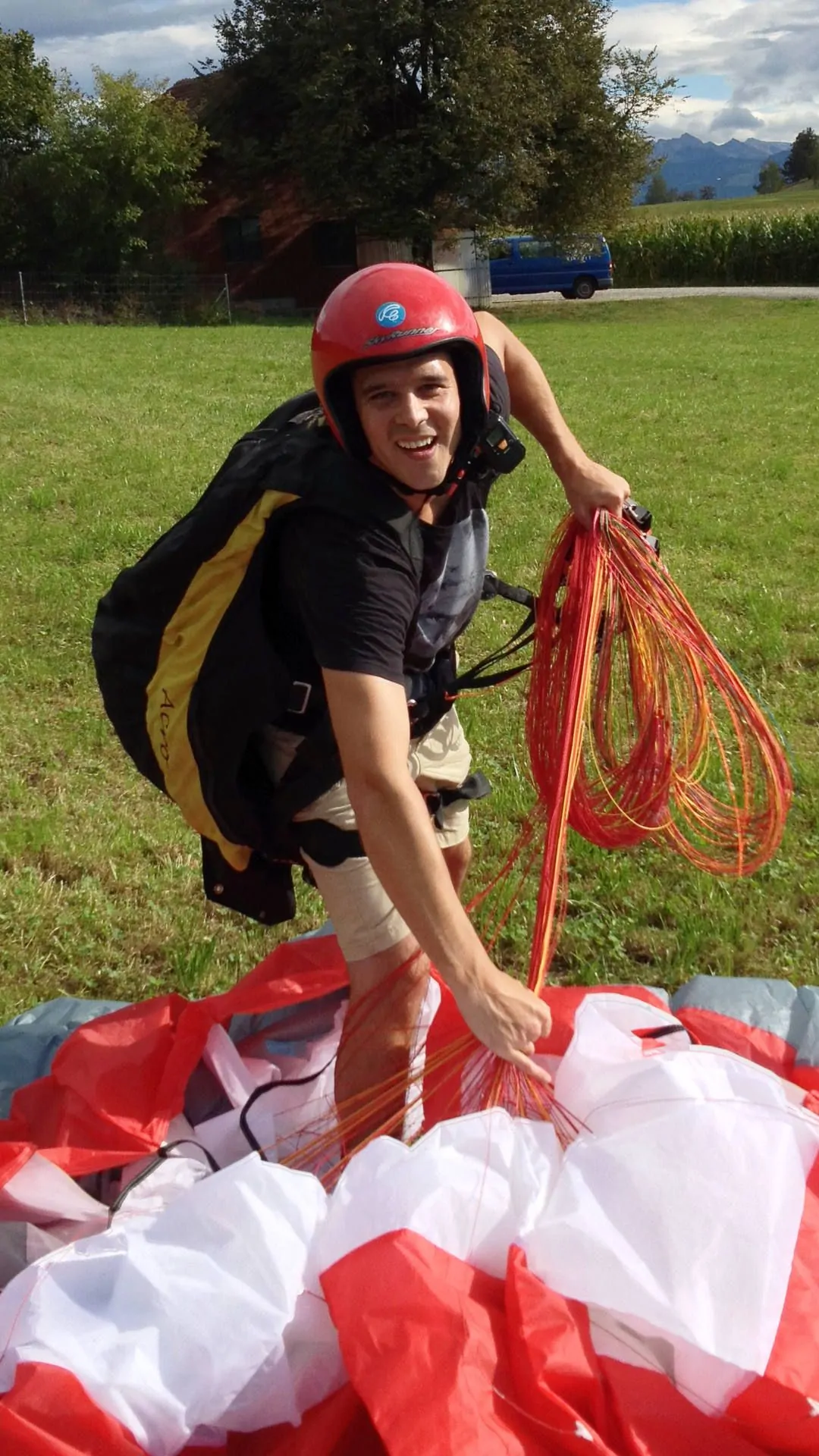 gleitschirm-flugschueler-schirm-zusammenraffen-hoch Ein Flugschüler mit glücklichem Gesichtsausdruck rafft nach einem kurzen Gleitflug am Übungshang den Schirm zusammen.