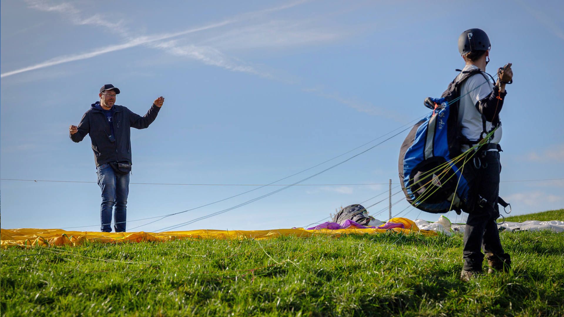 Ein Teilnehmer beim Gleitschirm-Schnuppertag ist startklar und bekommt letzte Tipps vom Instruktor.
