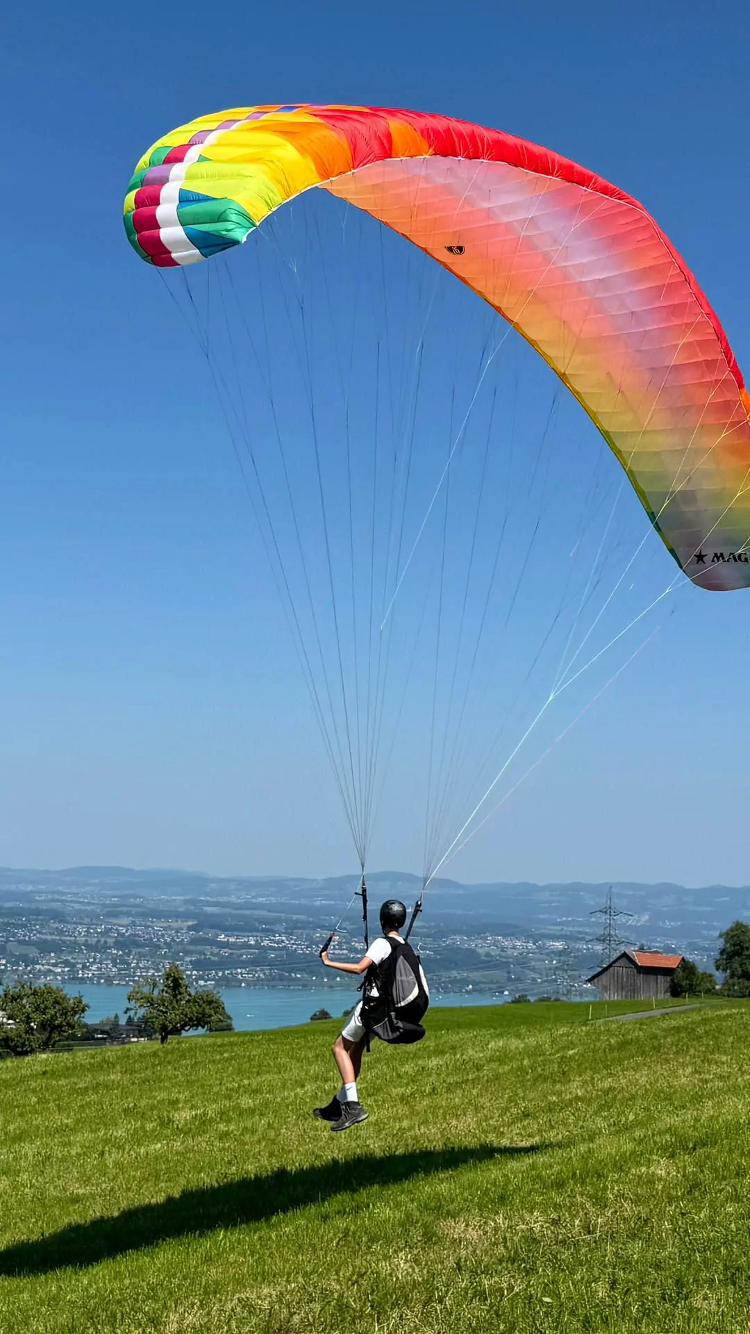 Ein Teilnehmer im Gleitschirm-Anhängerkurs ist mit entschlossenen Schritten zum ersten Gleitflug am Übungshang abgehoben und landet gleich.