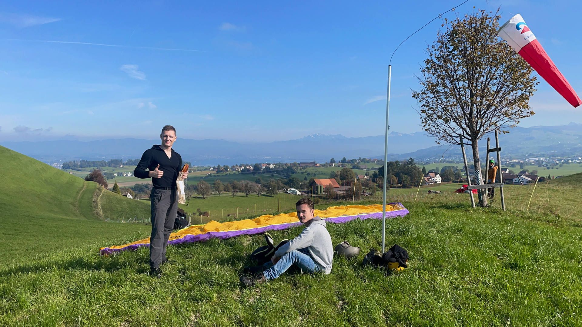 Zwei Flugschüler machen am Übungshang eine Pause um nach einer Zwischenverpflegung neue Übungen zu absolvieren.