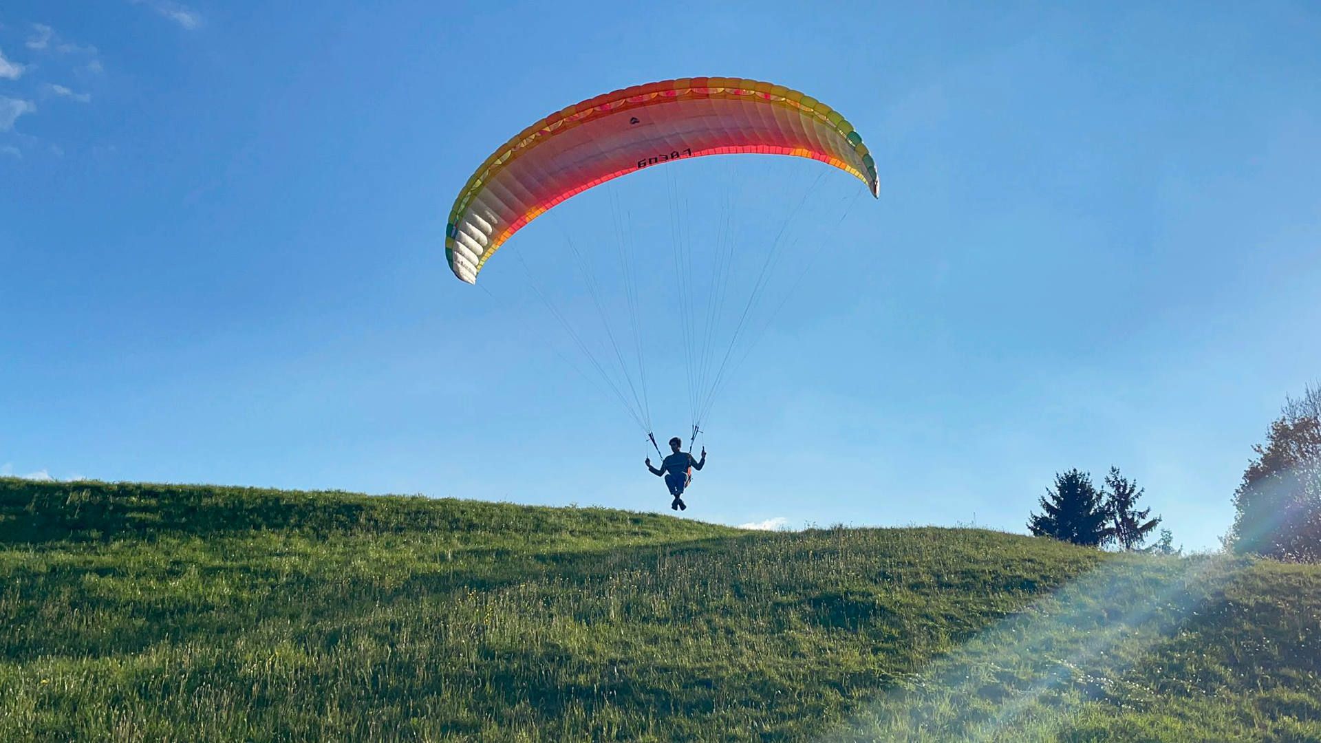 Ein Flugschüler hebt für einen kurzen Gleitflug am Übungshang ab und nimmt für den Flug eine sitzende Position ein.