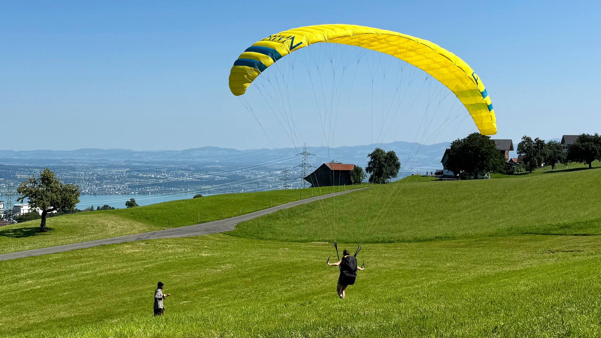 Eine Flugschülerin macht mit kontrollierten Schritten und dosiertem Einsatz der bremsen einen Slalomlauf am Übungshang.