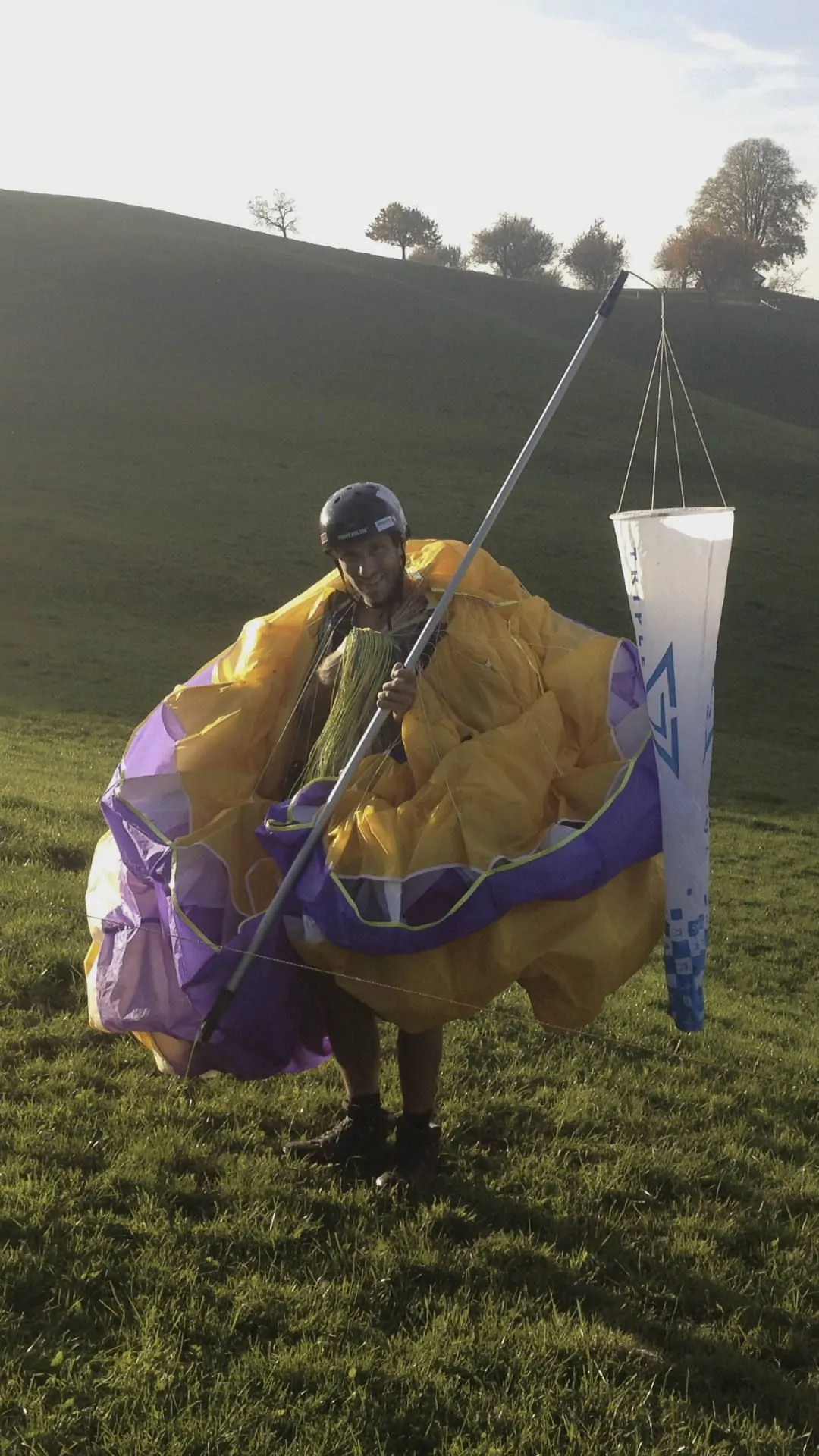 Nach einem erfolgreichen Tag am Übungshang packt ein Teilnehmer glücklich den Windsack ein.