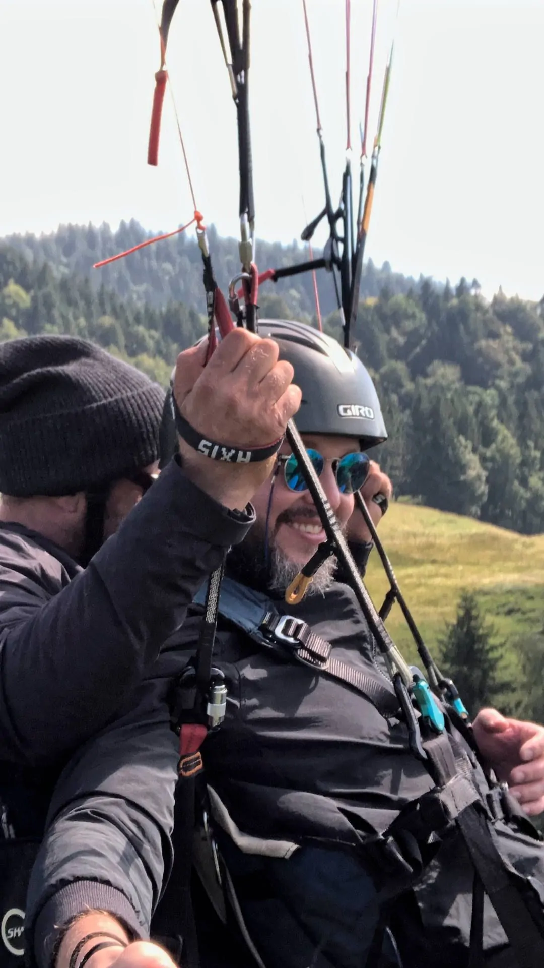gleitschirm-tandemflug-selfie-hoch Flugaufnahme: Während der Tandempassagier die Aussicht bei einem Gleitschirmflug geniesst, steuert der Pilot gezielt die nächste Aufwindquelle an.
