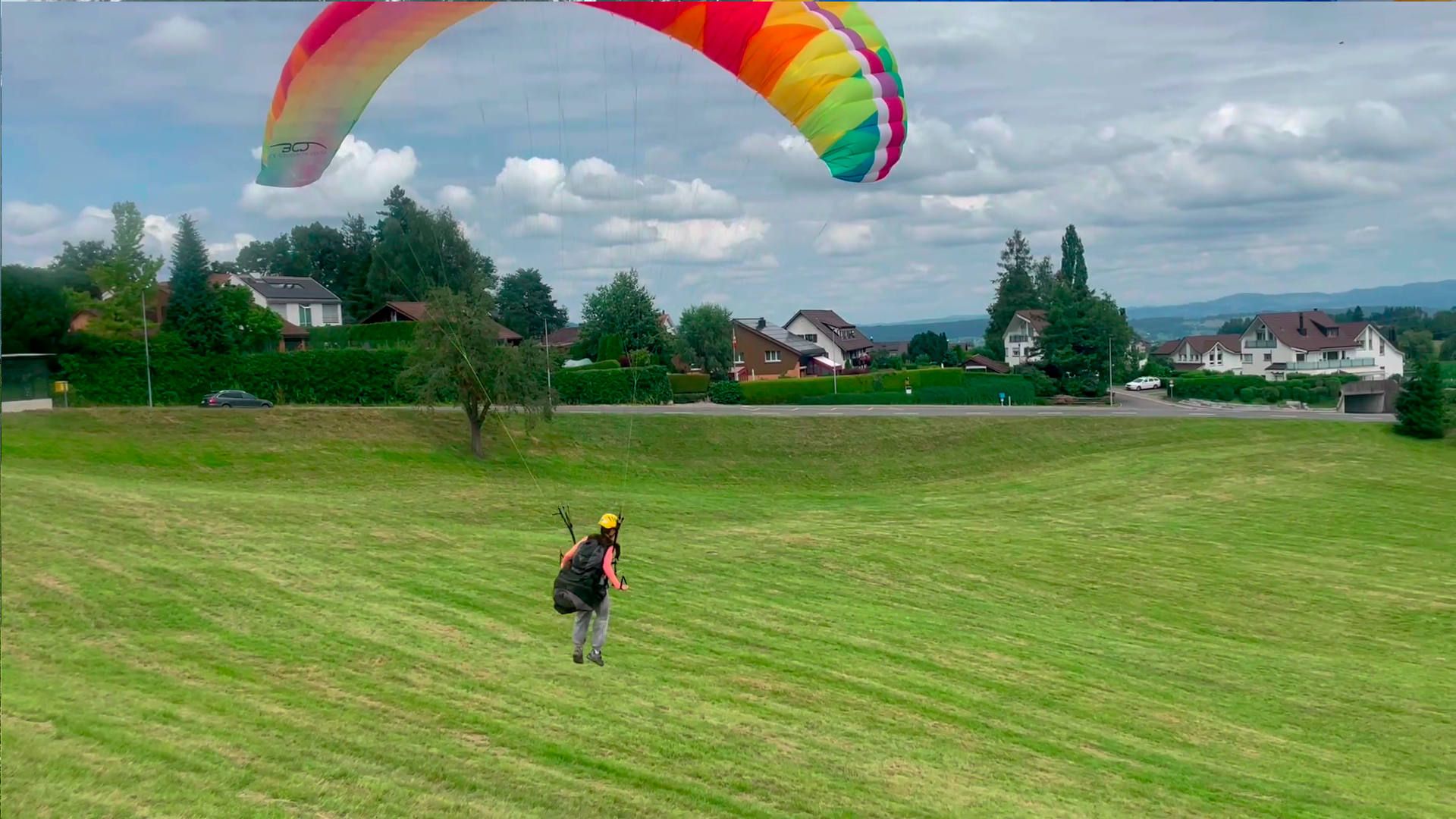 Eine Teilnehmerin zieht die Bremsen für eine sanfte Landung auf den Füssen bei einem Gleitschirm-Schnuppertag.