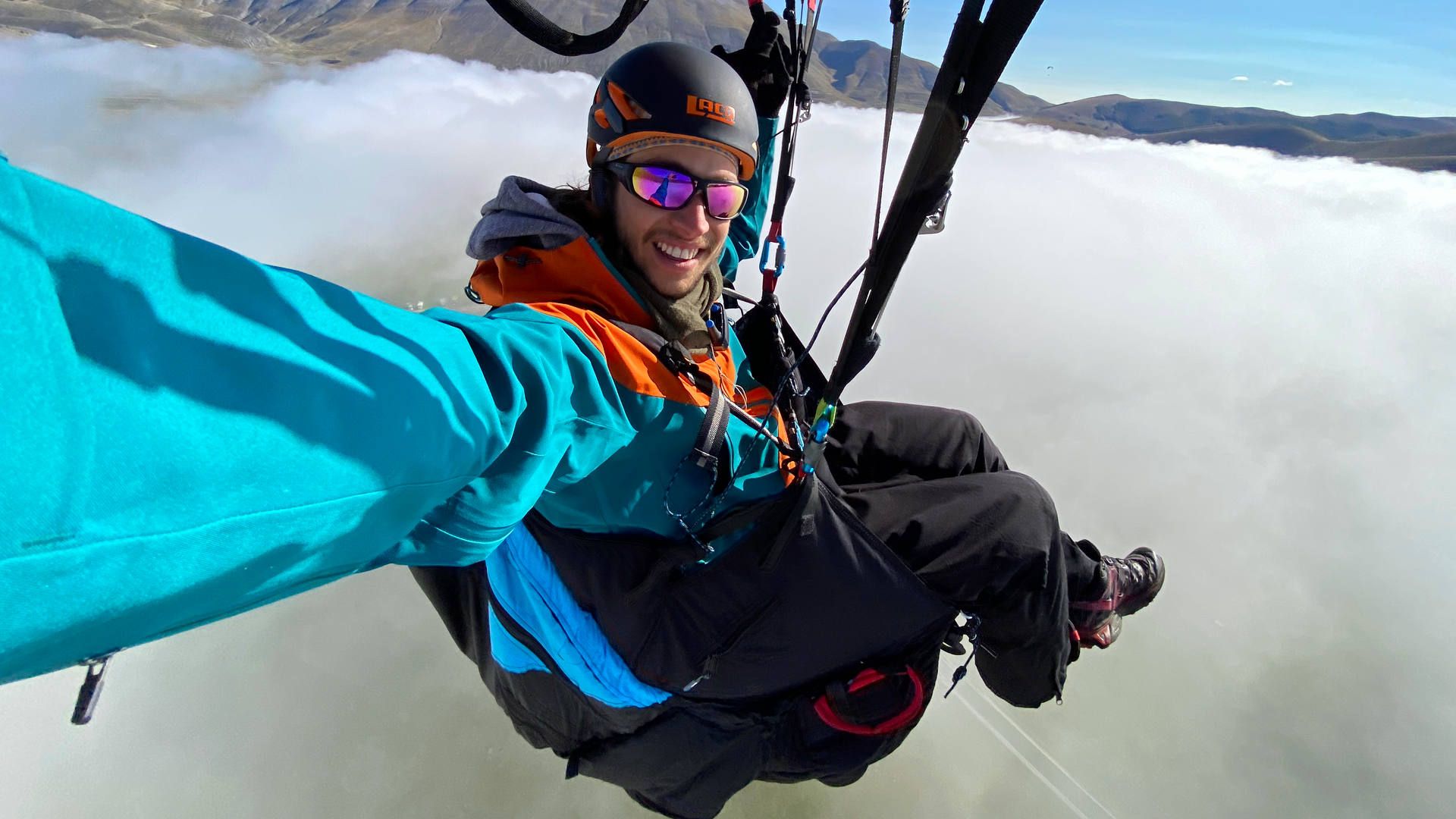 gleitschirmfliegen-herbst-flugaufnahme-thermikflug-nebelmeer-flugschueler-quer Flugaufnahme: Ein Gleitschirmpilot geniesst den magischen Moment, beim Eintauchen in ein sich auflösendes Nebelmeer.