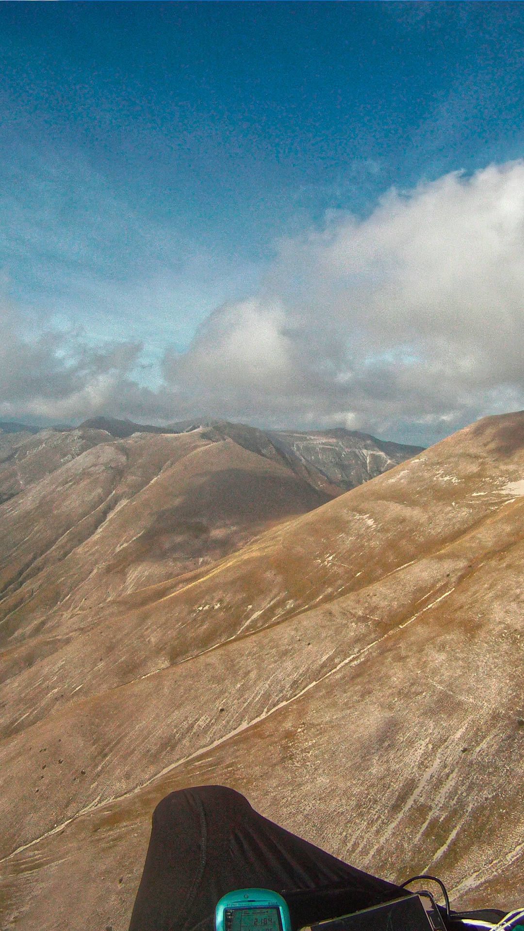 Flugaufnahme: Gleitschirm-Soaring entlang der Südflanke des Monte Vettore in Richting Castelluccio.