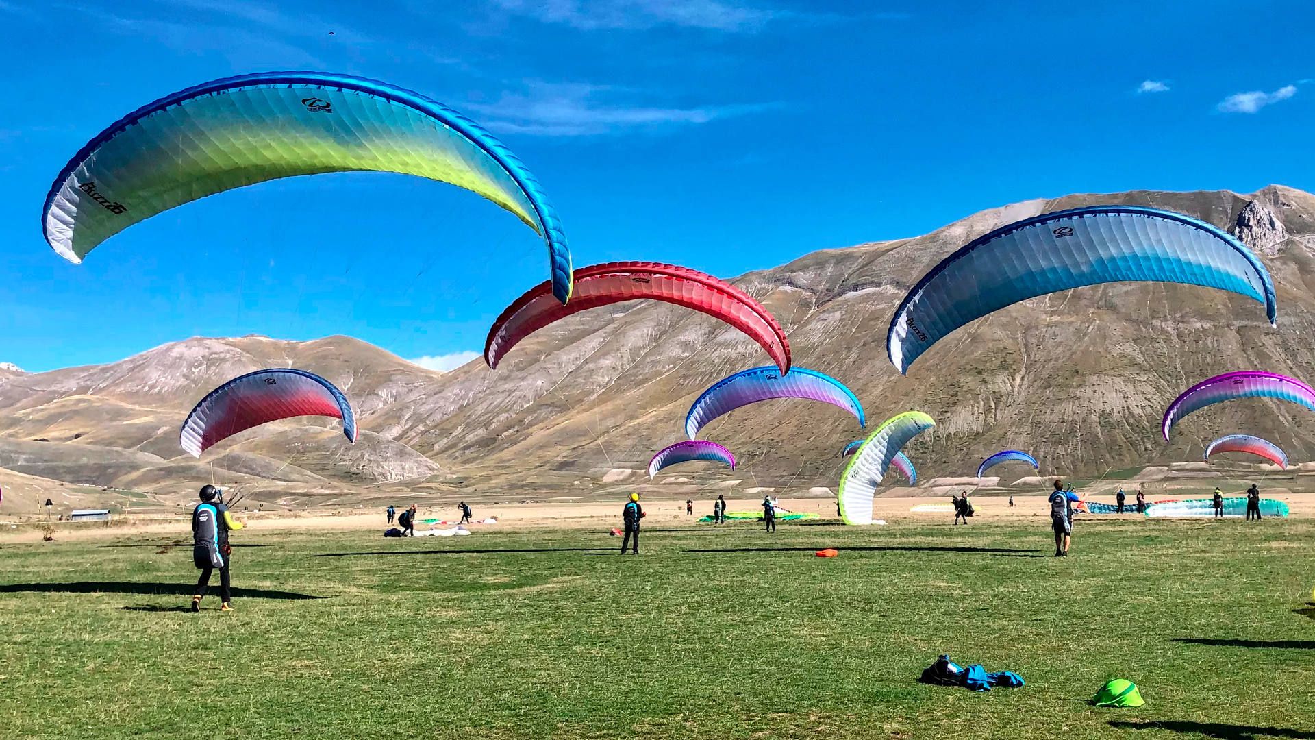 Mitten in der Ebene von Castelluccio herrschen übt ein Dutzend Flugschüler das rückwärts Aufziehen mit ihren Gleitschirm.