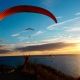 Abendliches Soaring für drei Gleitschirmpiloten an der Dune du Pyla kurz vor Sonnenuntergang.