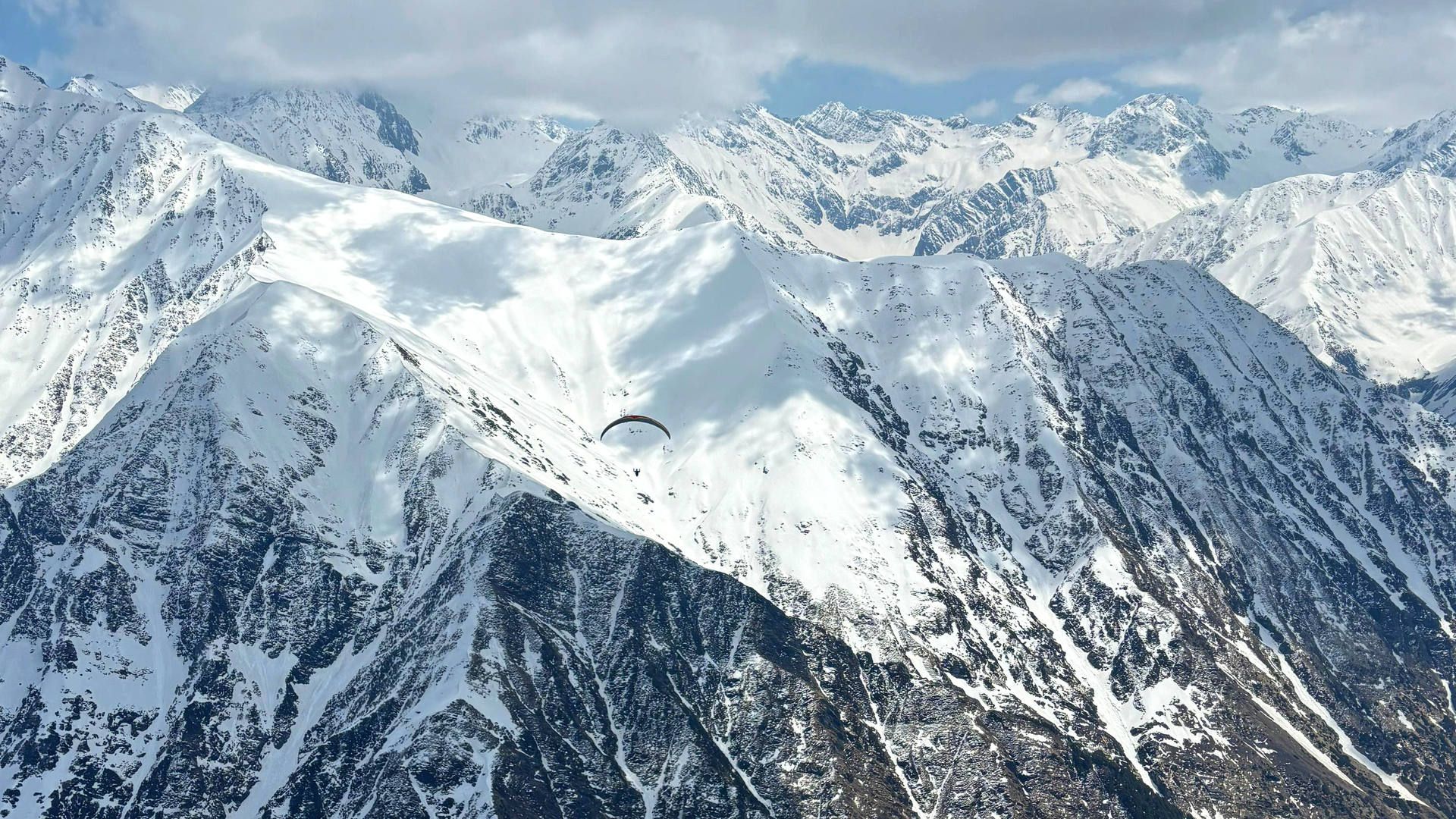 gleitschirmreise-bir-billing-flugaufnahme-streckenflug-back-mountains-quer Flugaufnahme: Bei einem Streckenflug von Bir-Billing in die Back-Mountains der Dhauladhar-Range nimmt ein Gleitschirmpilot Kurs auf die Eiswüsten.